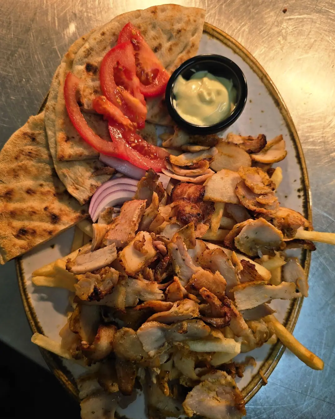 Chicken gyros over fries, with pitta, tomato, red onion and garlic mayonnaise